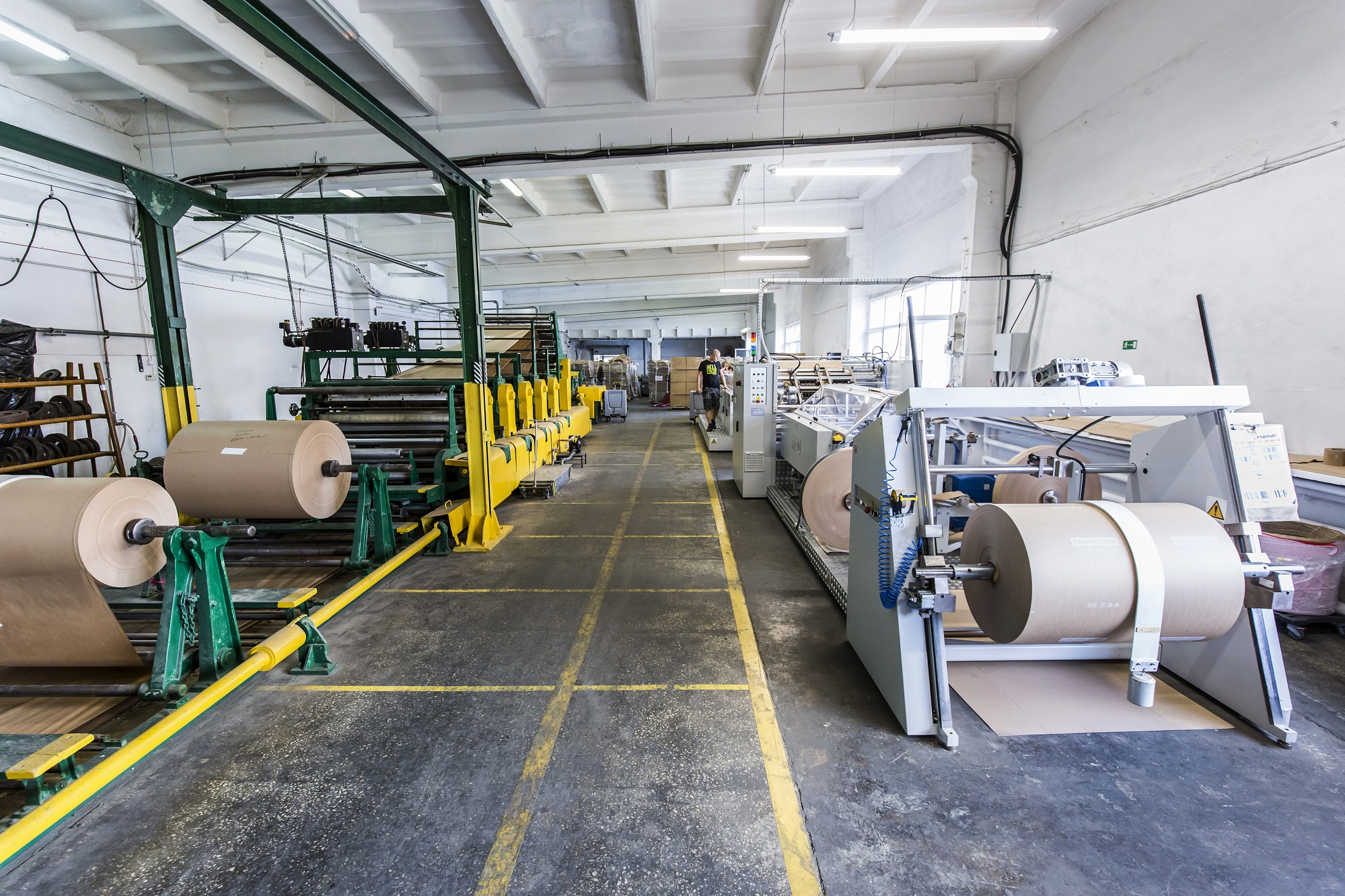maszyny z belami papieru na hali produkcyjnej