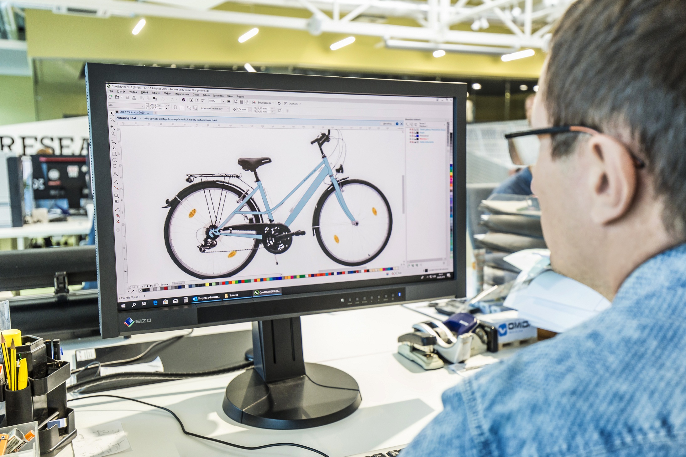 mężczyzna przed monitorem komputera z oprogramowaniem do projektowania rowerów